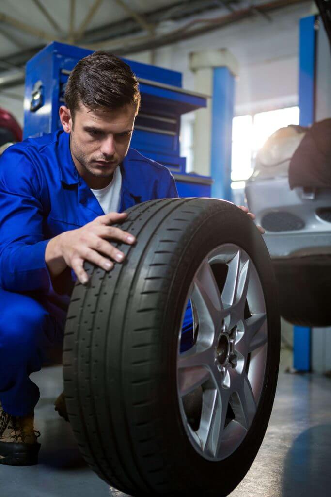 Mechanic inspecting a tyre as part of an MOT check in Peterborough